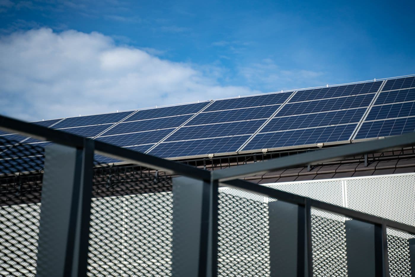 Rooftop solar panels angled towards a blue sky